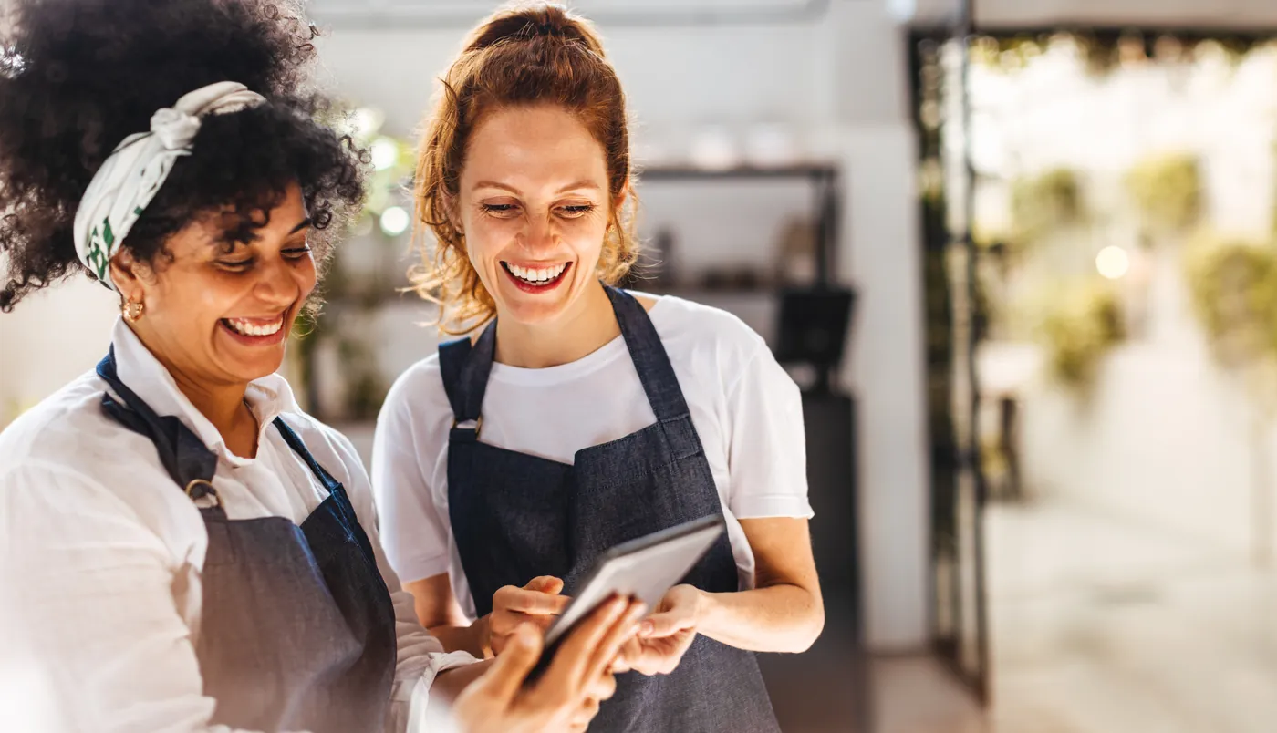 Two colleagues smiling over a tablet