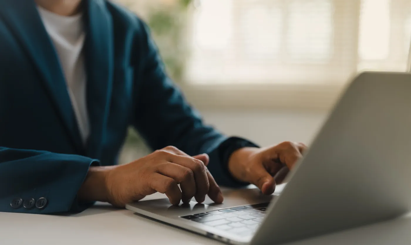 Hands typing on a laptop