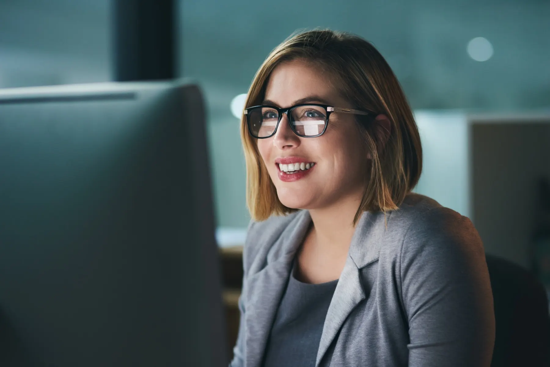 A team member smiling while working at a monitor