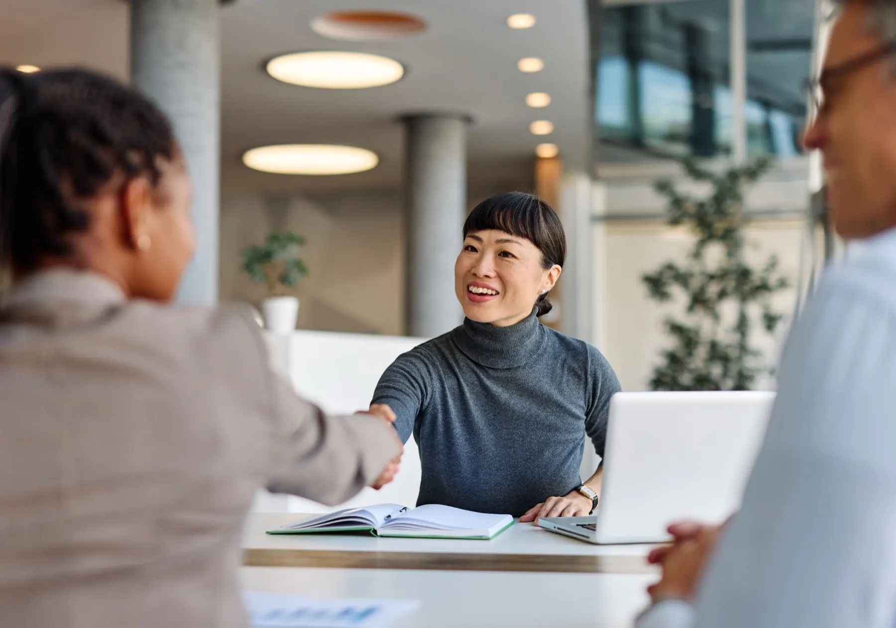 A client and advisor shaking hands across a desk